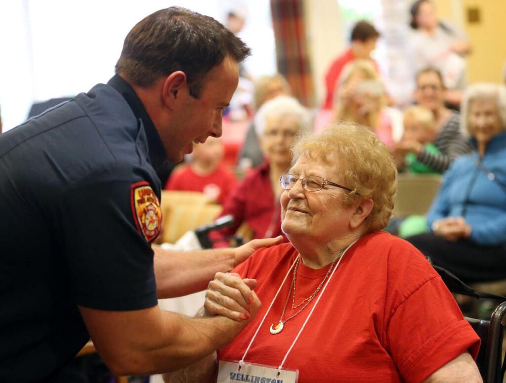 Firefighter shakes hands with elderly woman