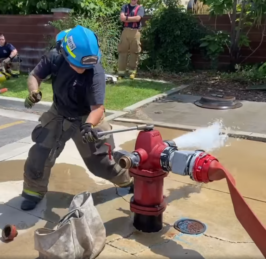 firefighter connecting hose to hydrant