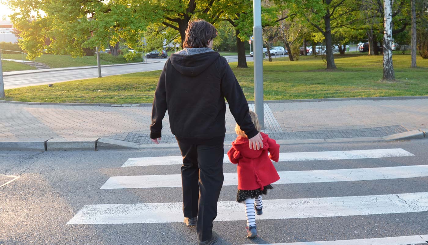 father and daughter crossing the street