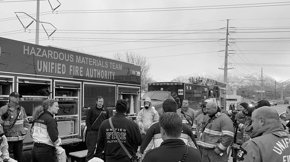 Firefighters stand beside engine