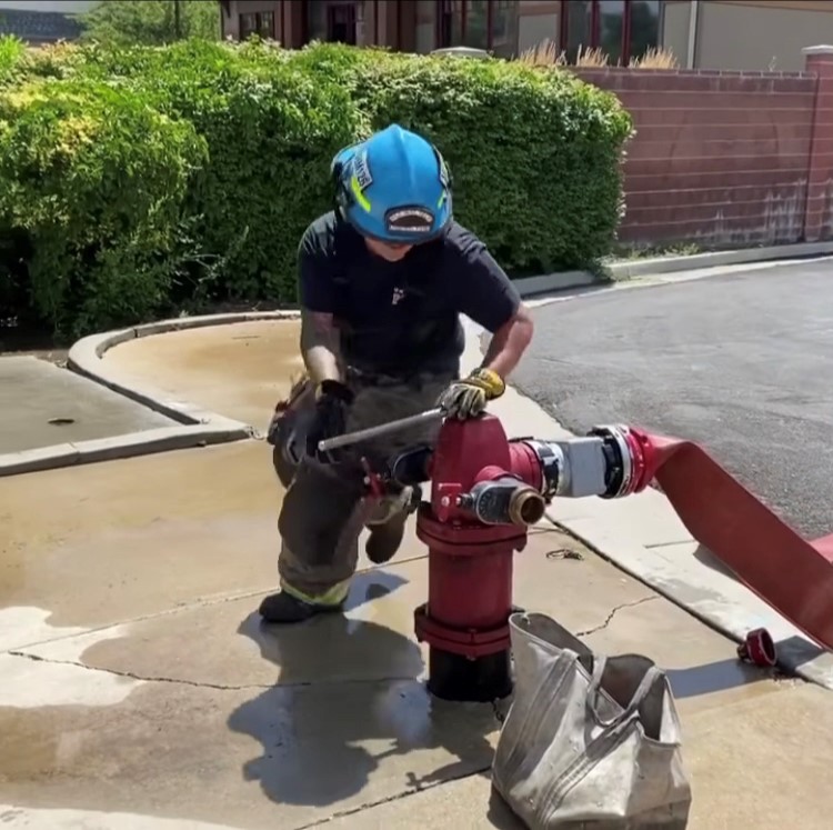 firefighter hooking up to hydrant