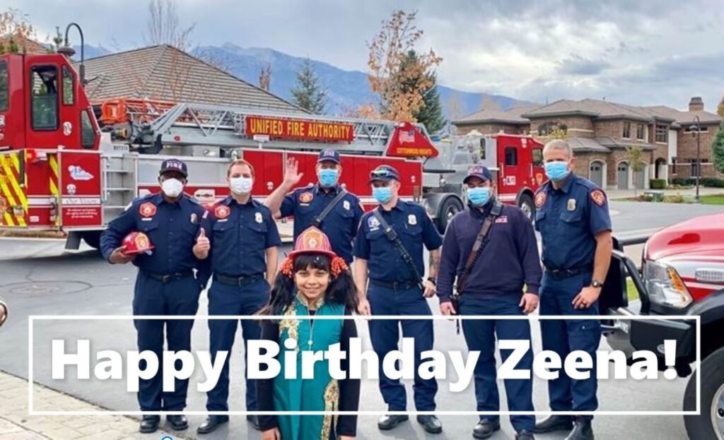 Happy Birthday Zeena, girl stands in front of fireifghters